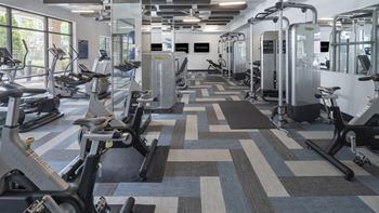 A fitness room with cardio machines and other exercise equipment